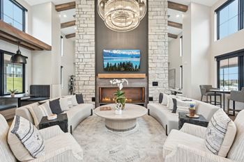 A modern living room with a fireplace and a large TV above it.at The Garrison Luxury Apartment Homes, Fountain, CO